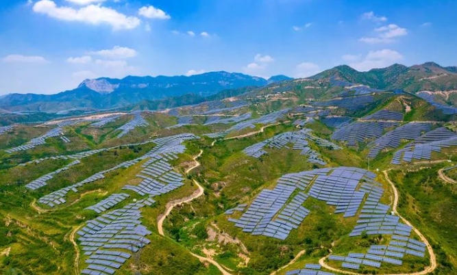 At the 100MW photovoltaic-storage integrated project base in Jishan County, Yuncheng City, Shanxi Province, rows of neat photovoltaic panels and the distant green mountains complement each other.