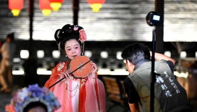 Tourists dressed in ancient costumes were taking pictures while taking a night tour at the Yanghe Tower in Zhengding County